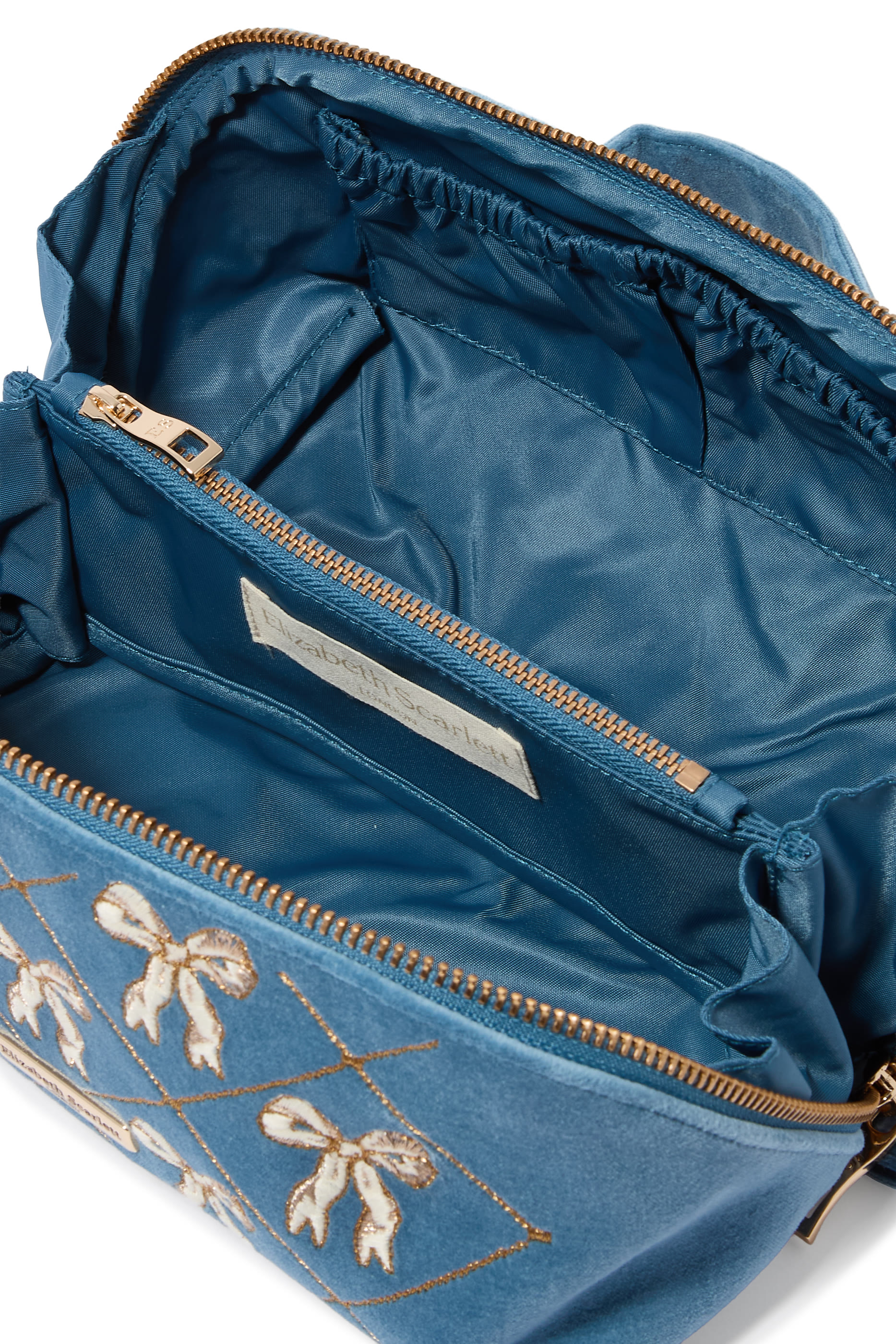 حقيبة مستحضرات التجميل مفتوحة ومسطحة مزينة بفيونكات مخمل